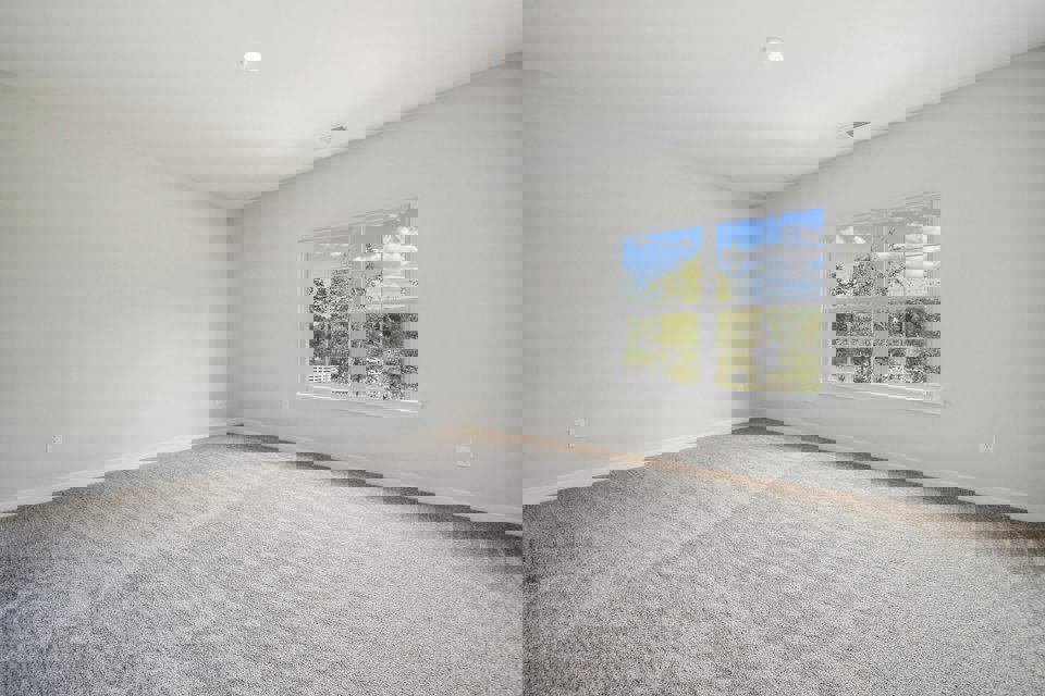 A room with a window and a carpet.