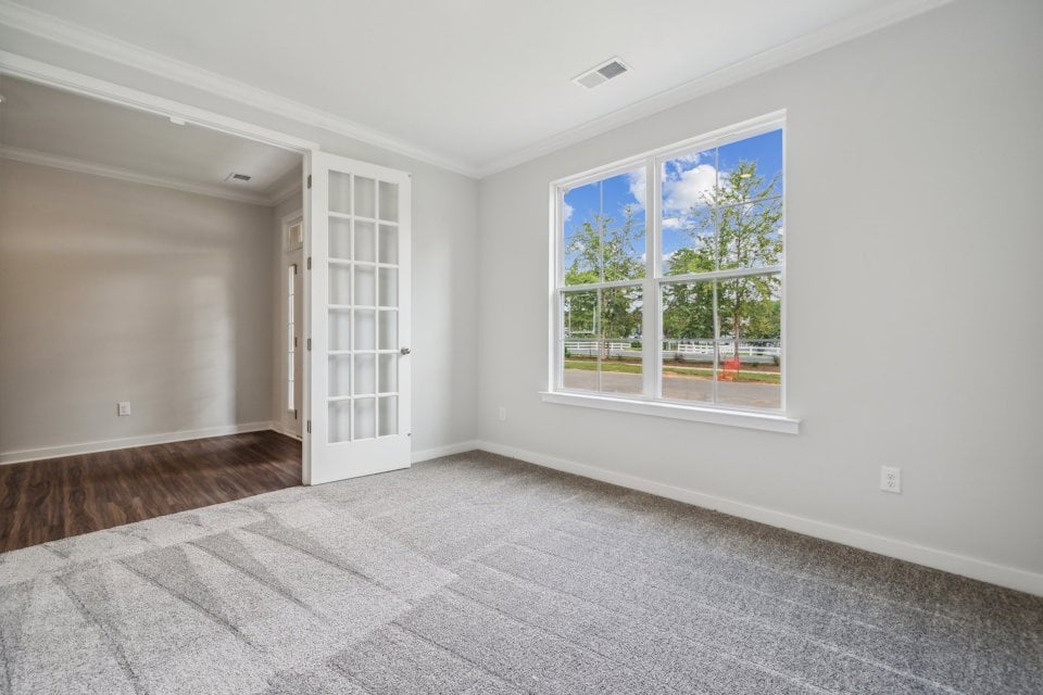 A room with a window and a rug.