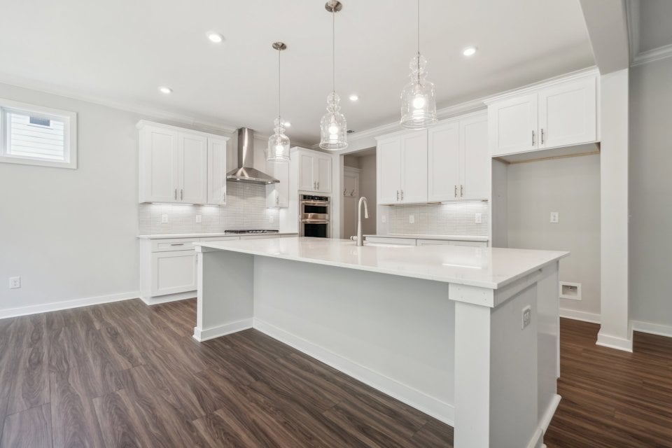 A kitchen with white cabinets.