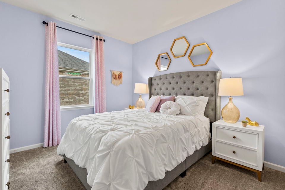 A bedroom with a bed and lamps.