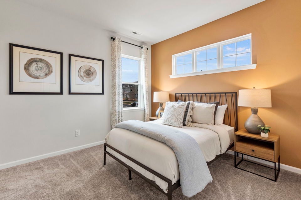 A bedroom with a bed and lamps.