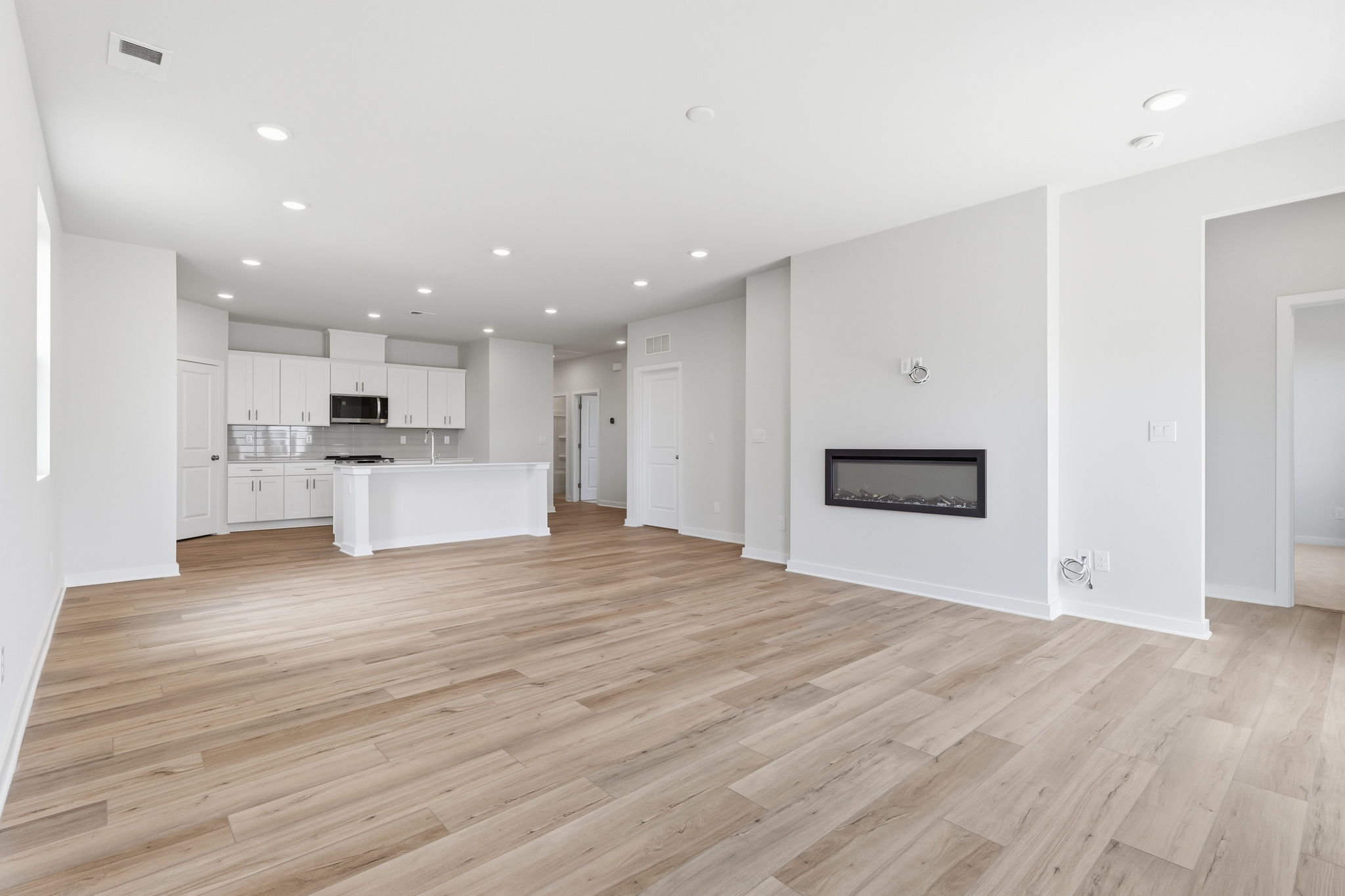 A large white room with a wood floor and white walls.