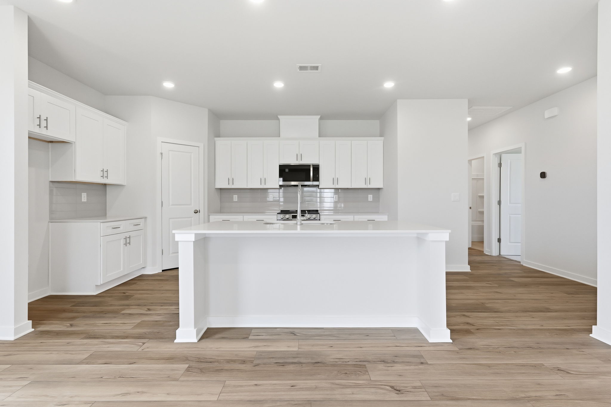 A large white kitchen with white cabinets.