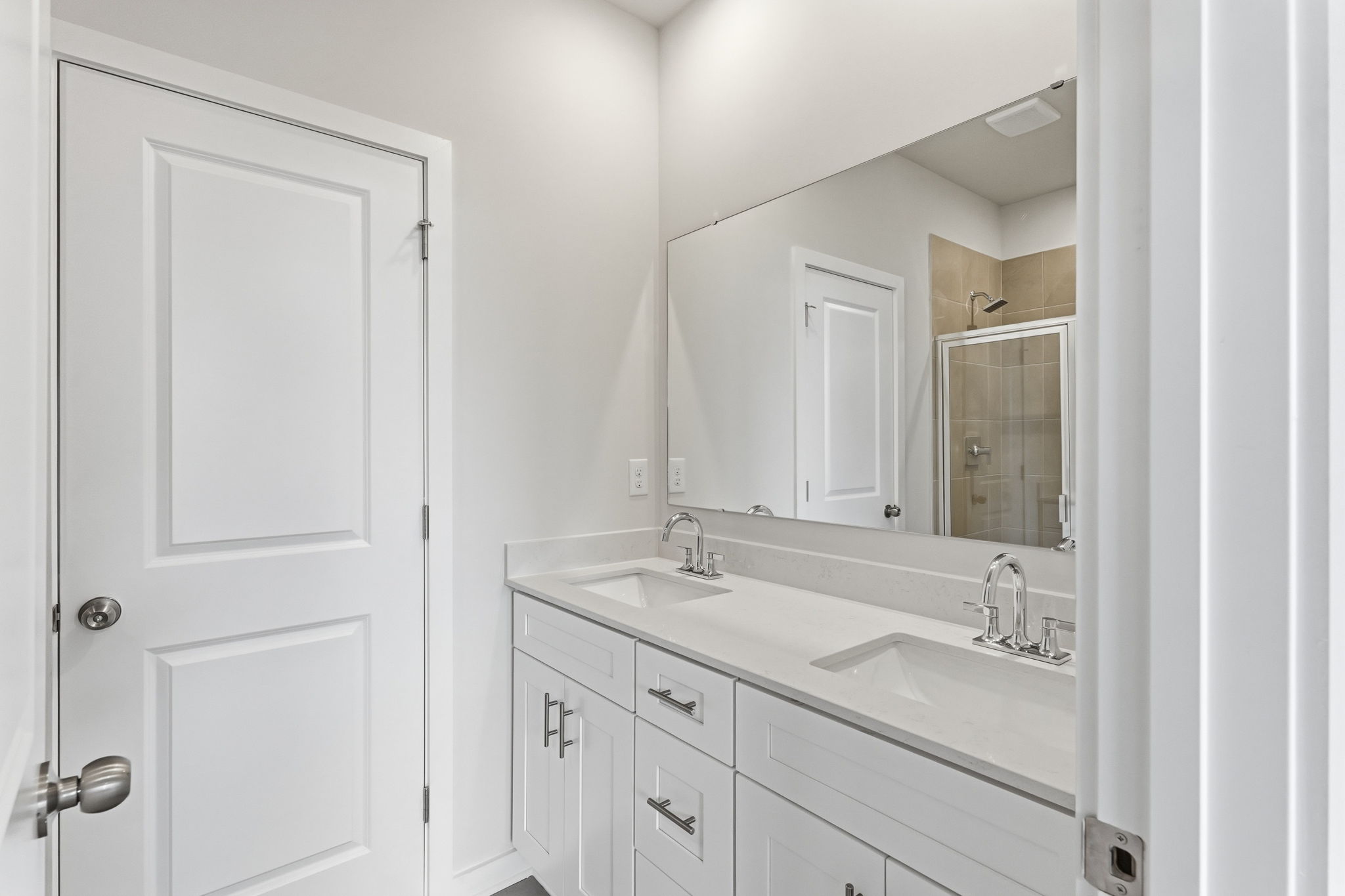 A bathroom with white cabinets.