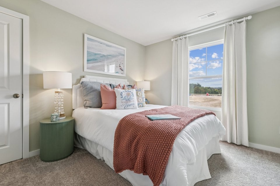 A bedroom with a large window.