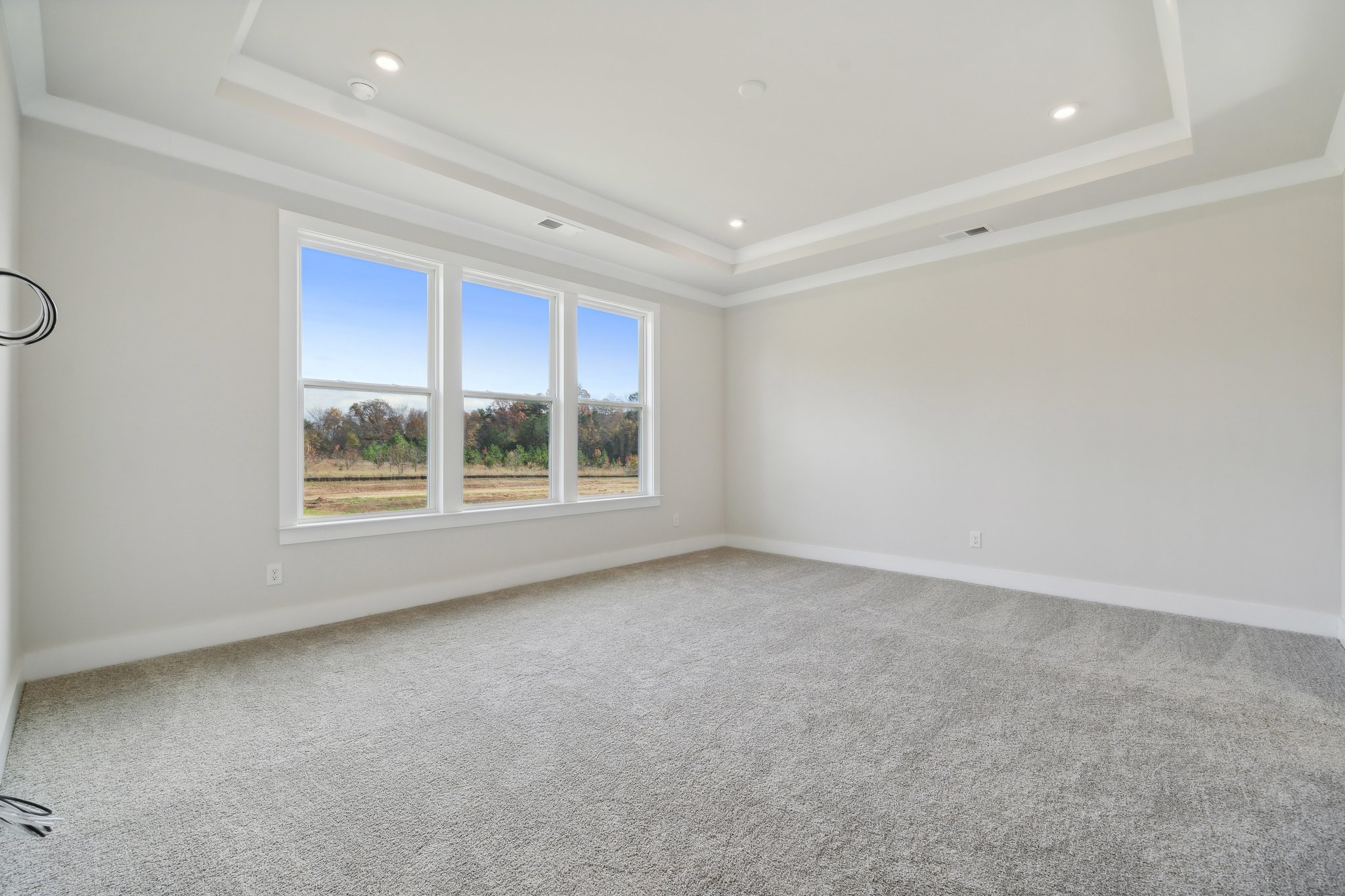 A room with a window and a carpet.