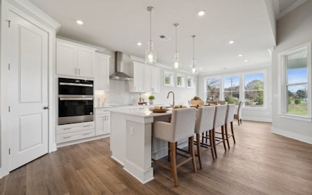 A kitchen with a dining table and chairs.