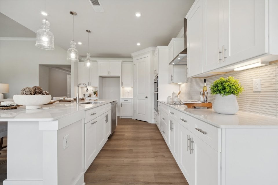 A kitchen with white cabinets.