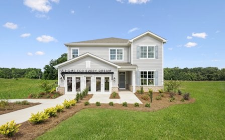 A white house with a lawn.