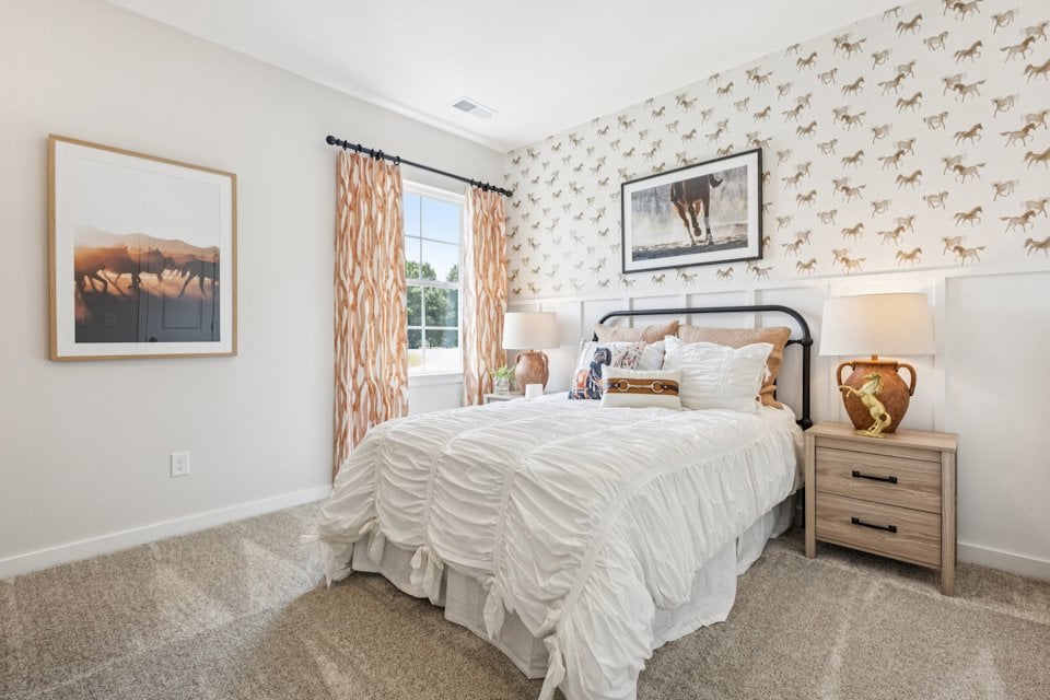 A bedroom with a bed and lamps.