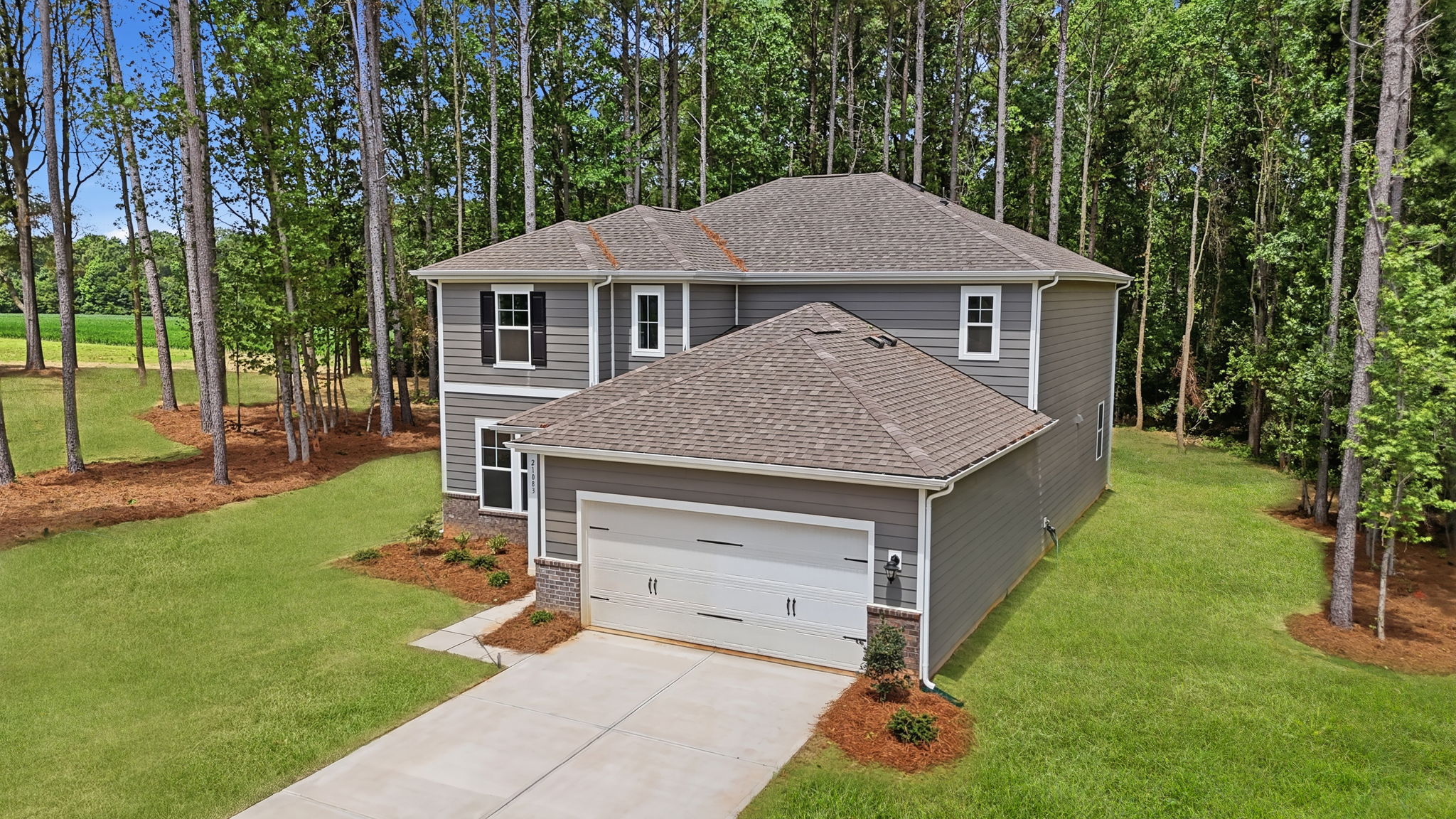 A house with a garage in a wooded area.