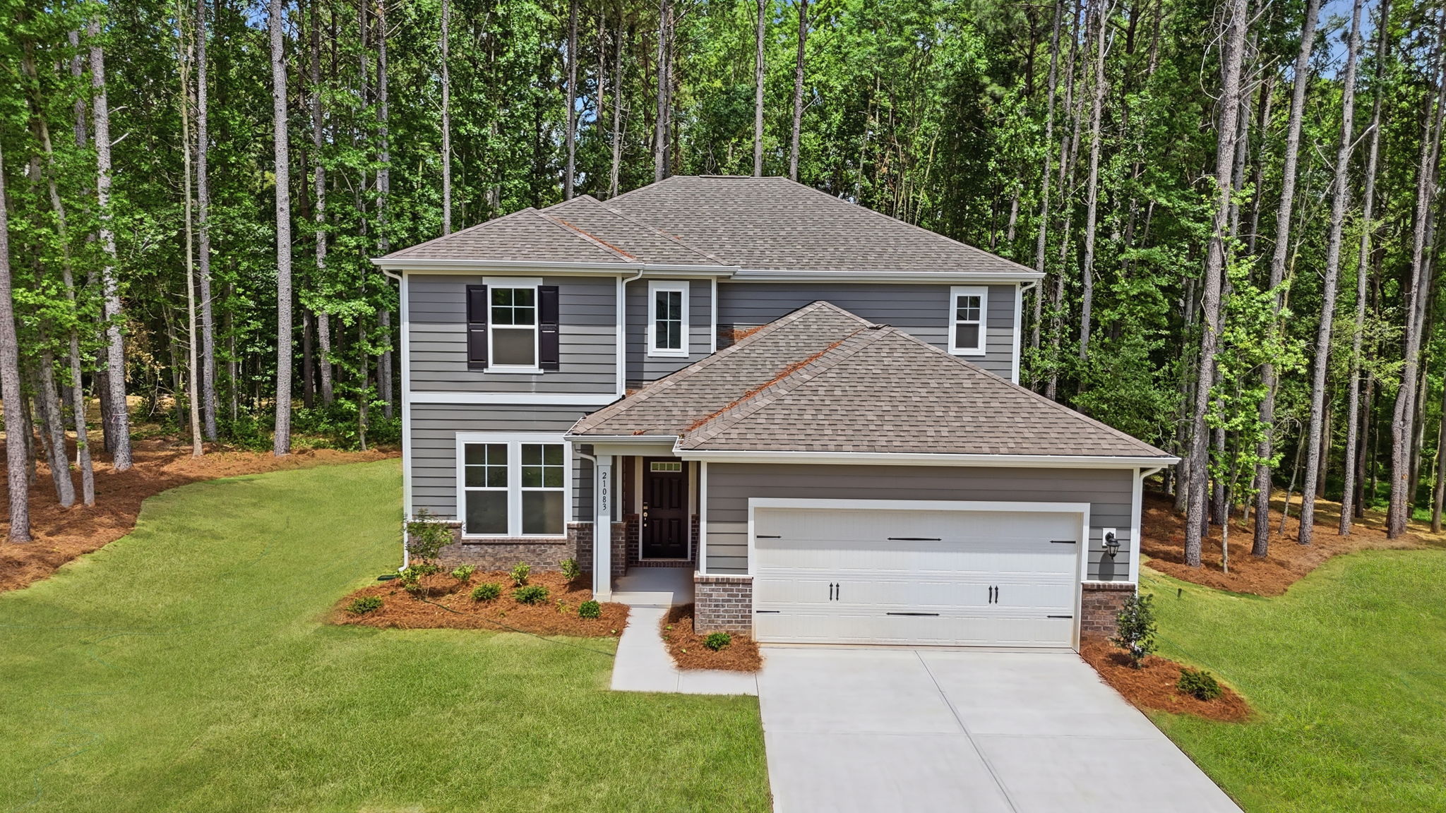 A house with a garage and trees around it.