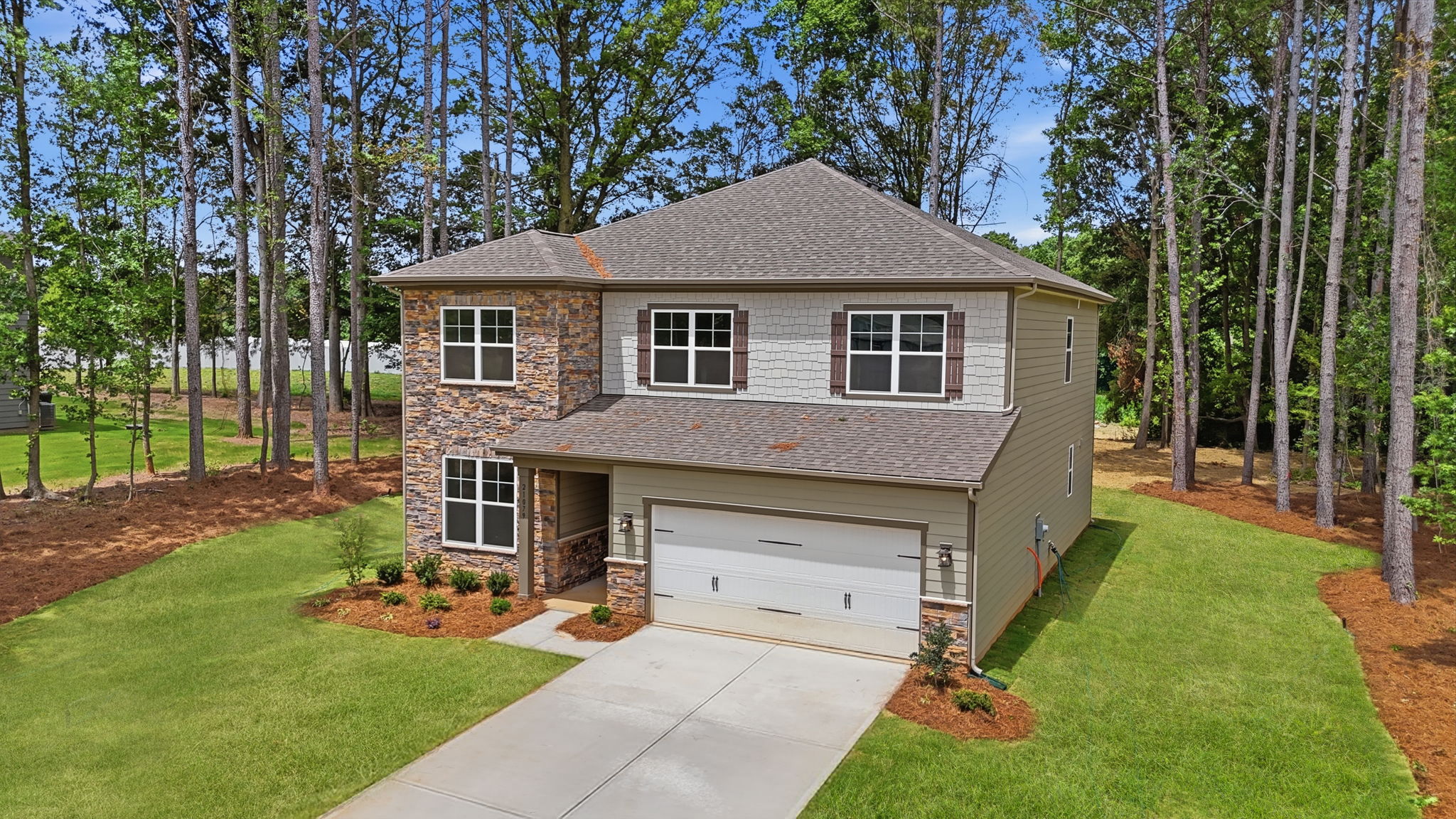A house with a garage and trees around it.