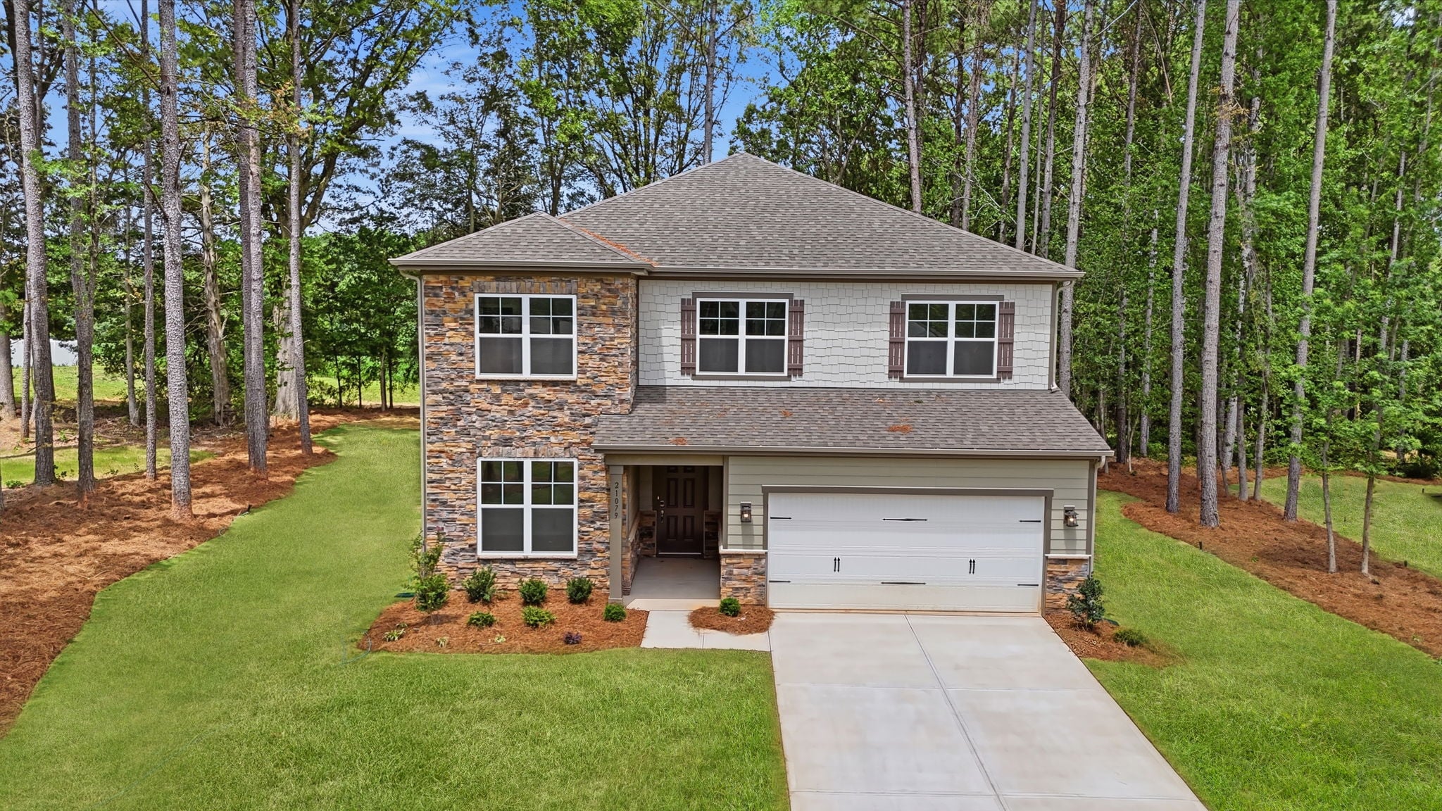 A house with a garage and trees around it.