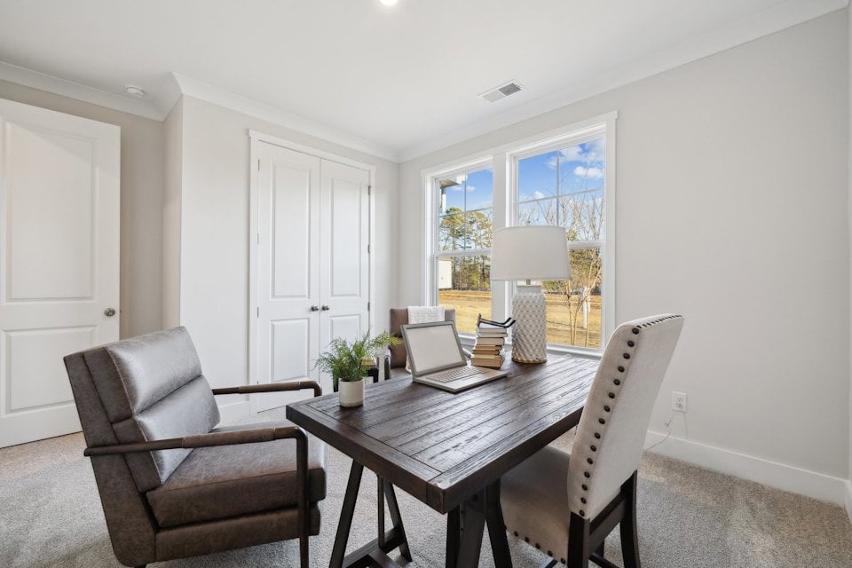 A living room with a table and chairs.