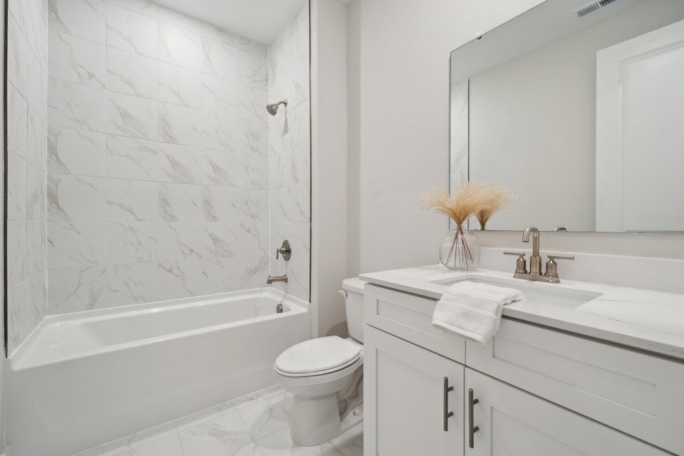 A bathroom with a tub sink and toilet.