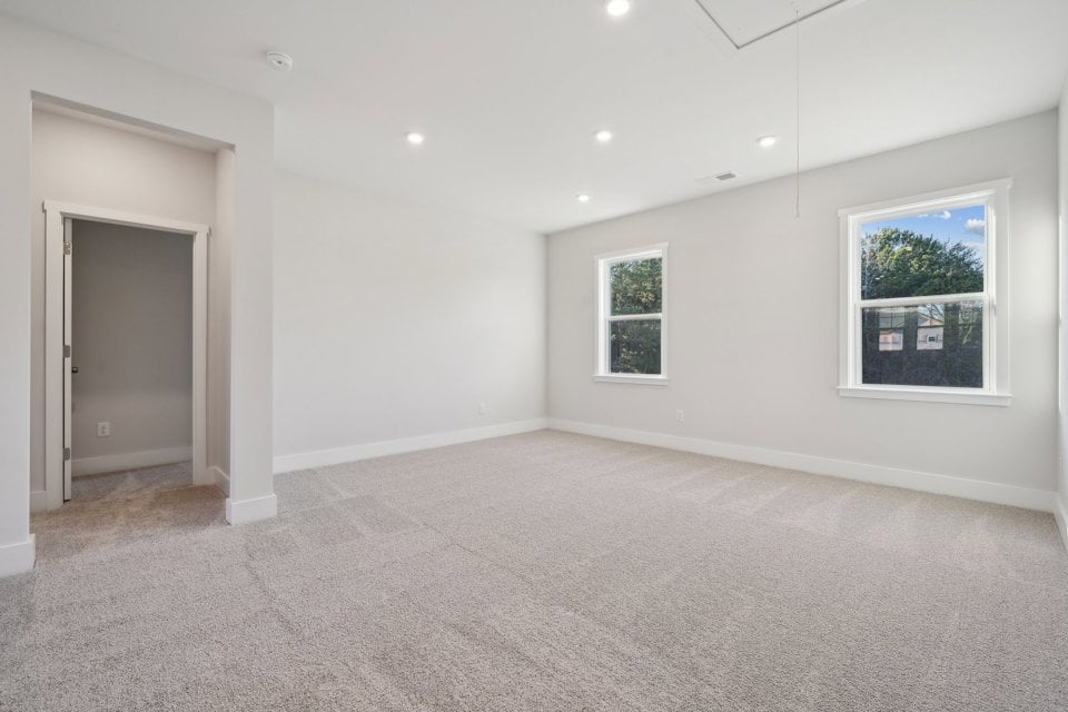 A room with a carpet and windows.