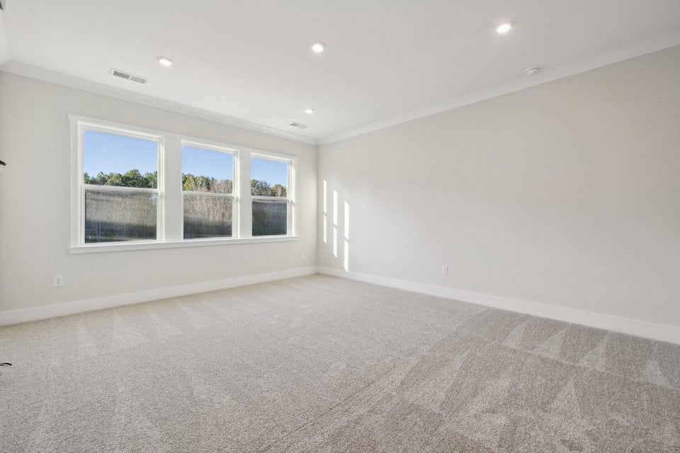 A room with a carpet and a window.