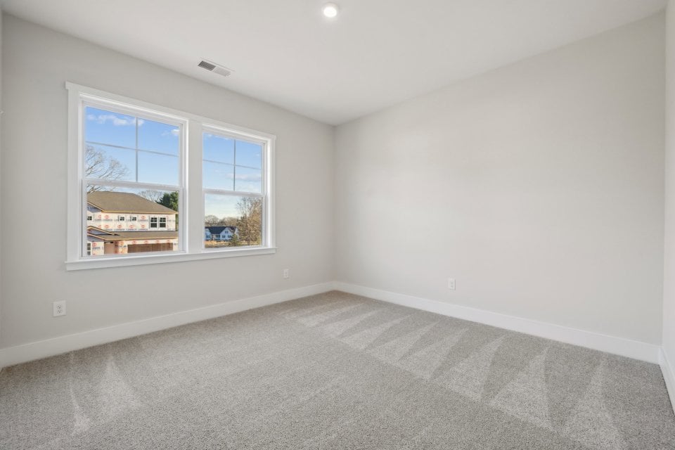 A room with a window and a carpet.