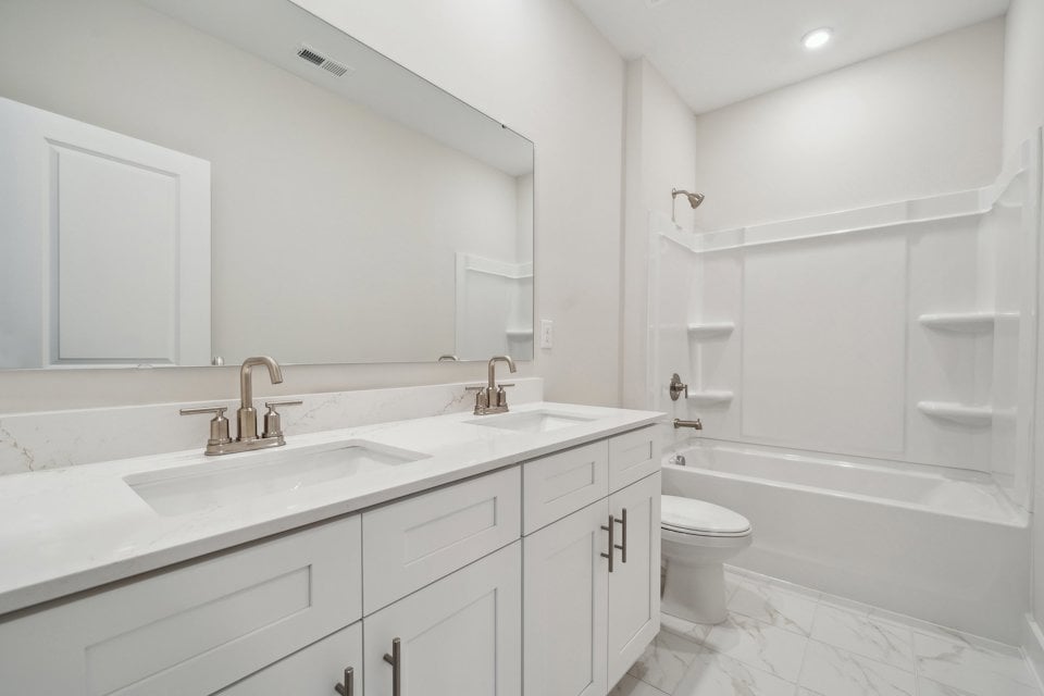 A bathroom with a tub sink and toilet.