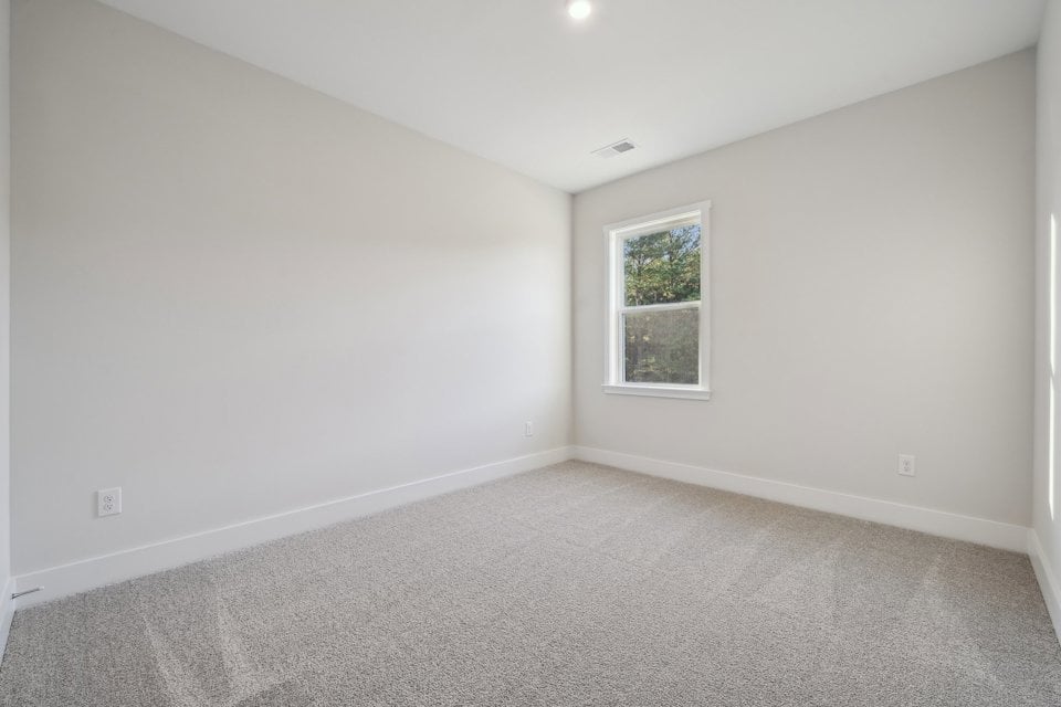A room with a window and carpet.