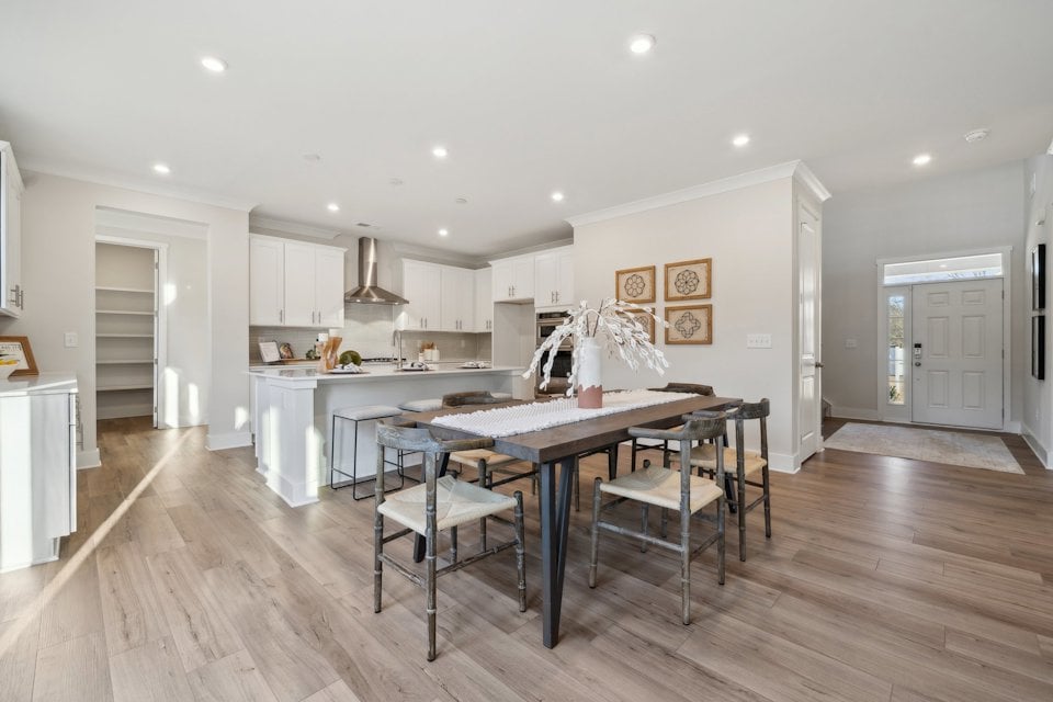 A kitchen with a dining table and chairs.