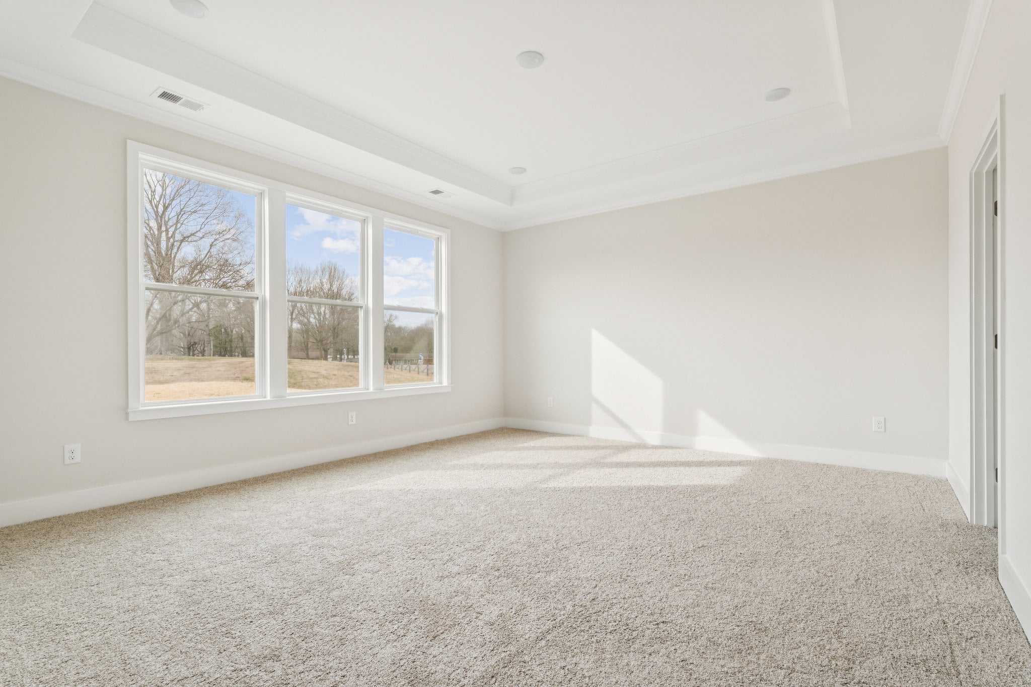 A room with a window and a carpet.