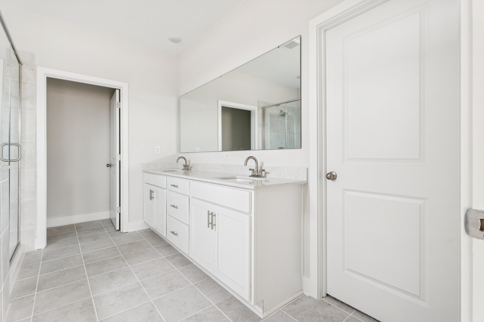 A bathroom with white cabinets.