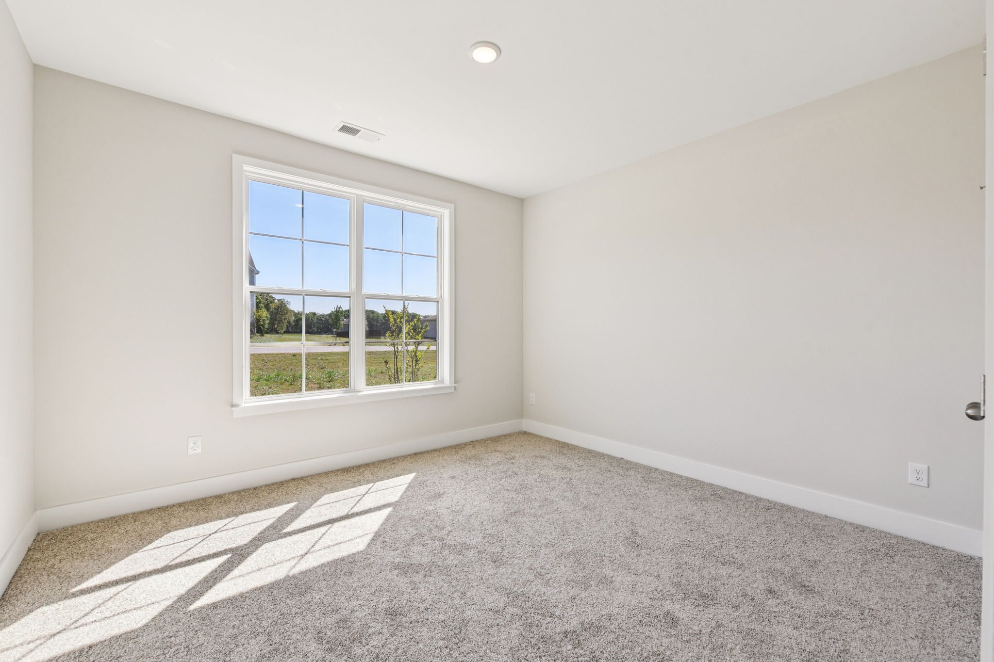 A room with a window and a rug in it.
