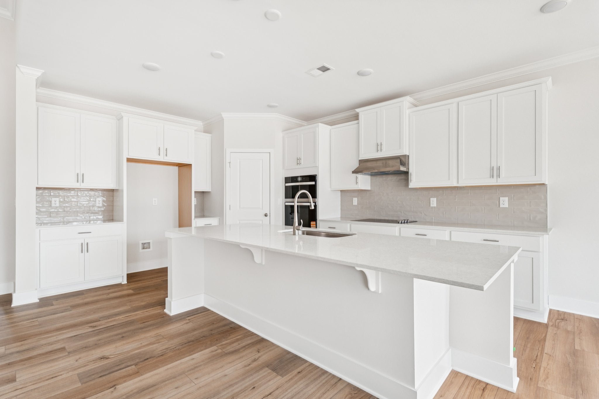 A kitchen with white cabinets.