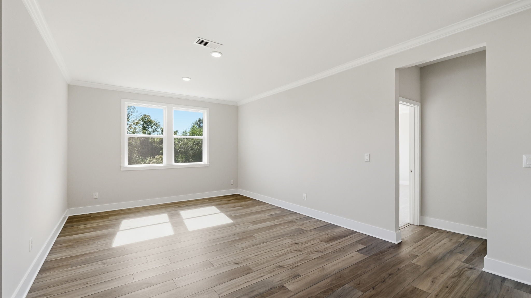 A room with a wood floor and a window.