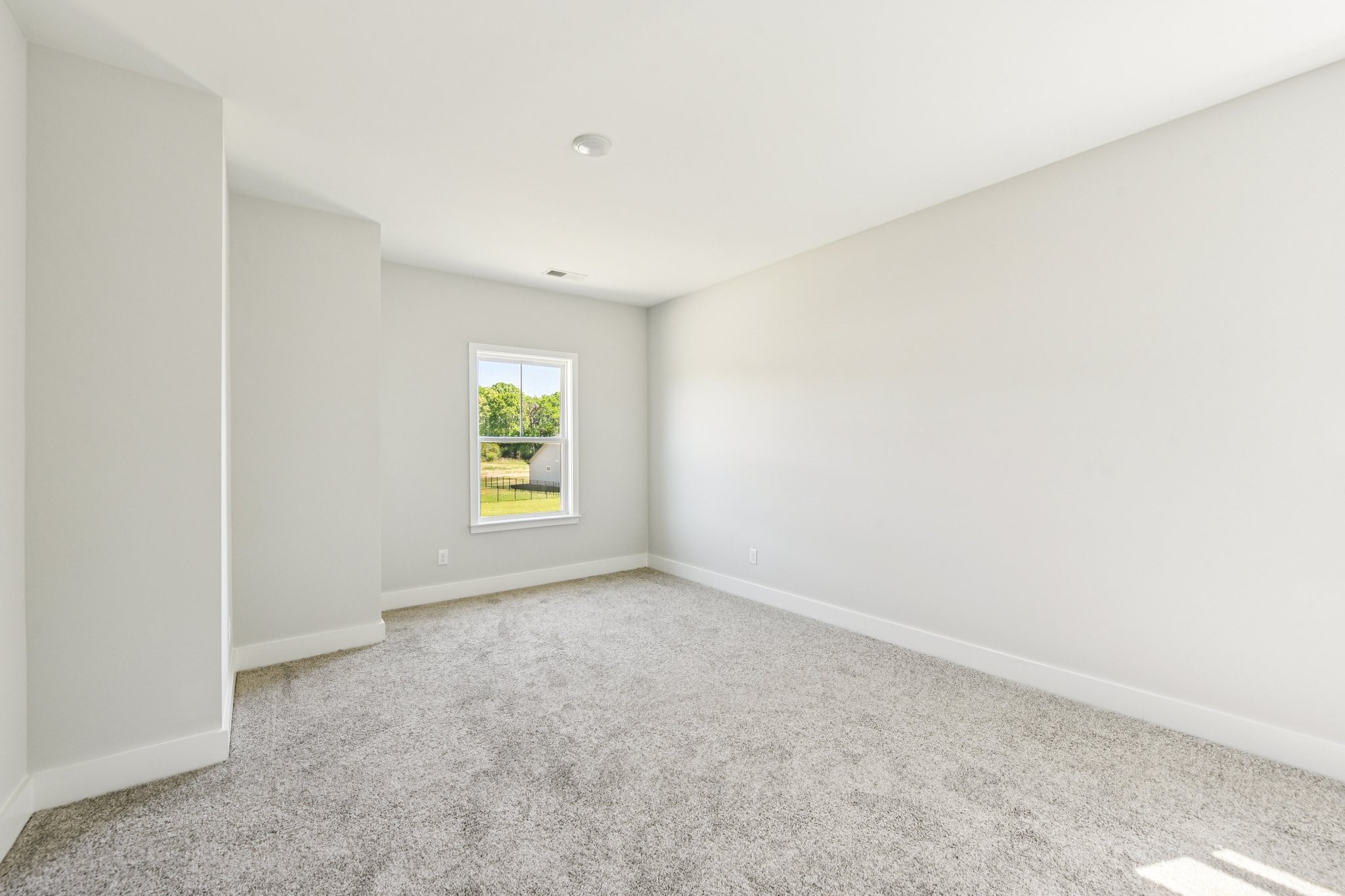 A room with a window and carpet.
