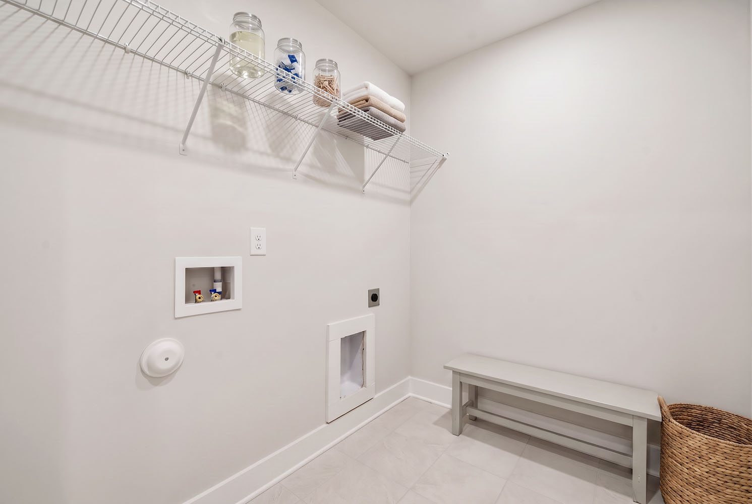A white room with a white wall and a shelf with objects on it.