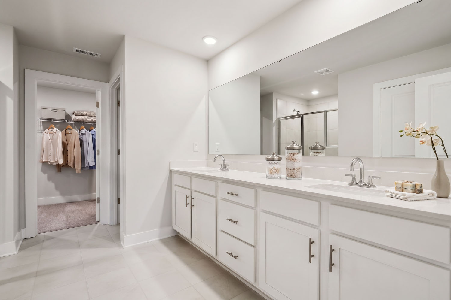 A bathroom with white cabinets.