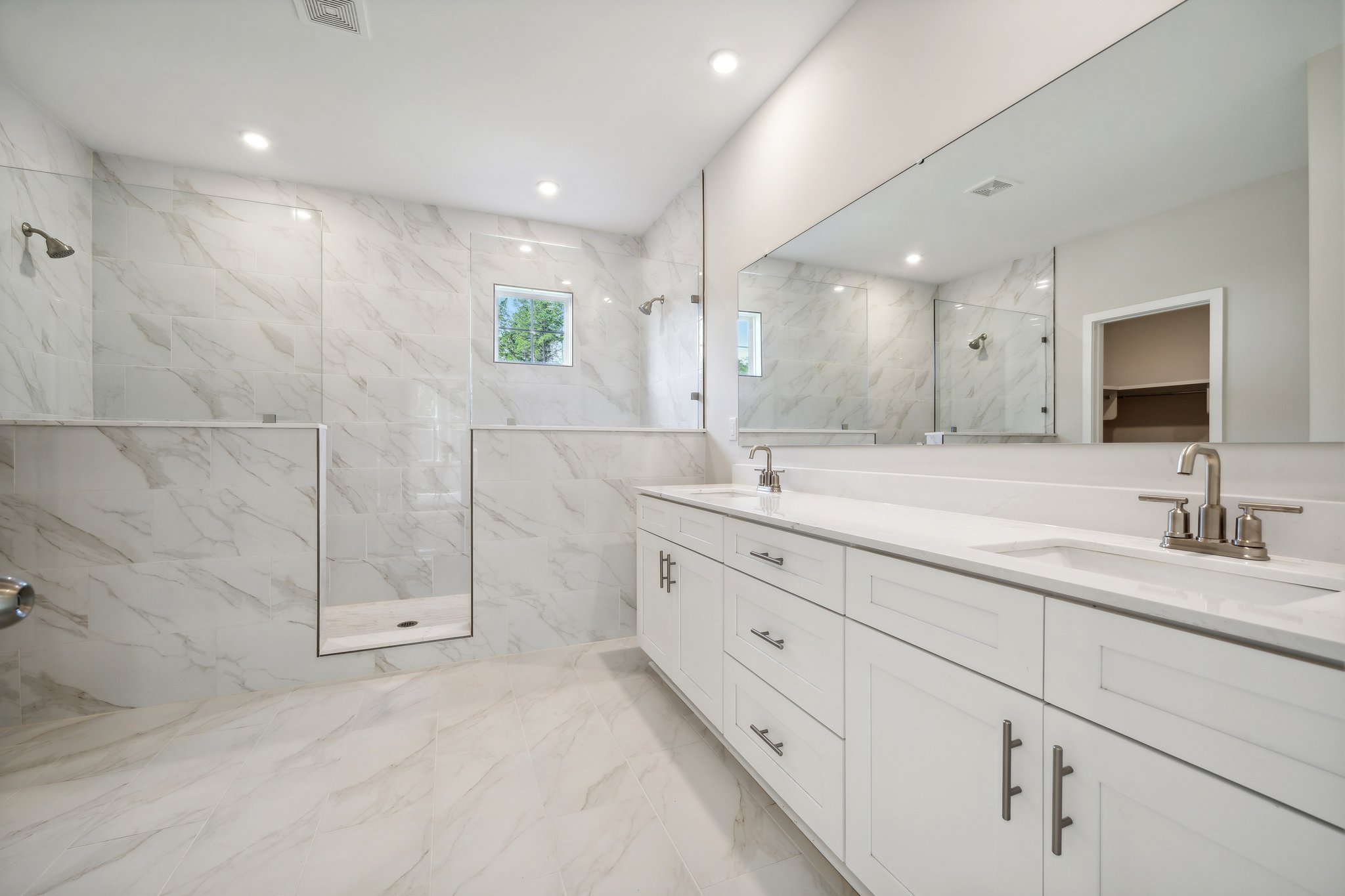 A bathroom with white cabinets.
