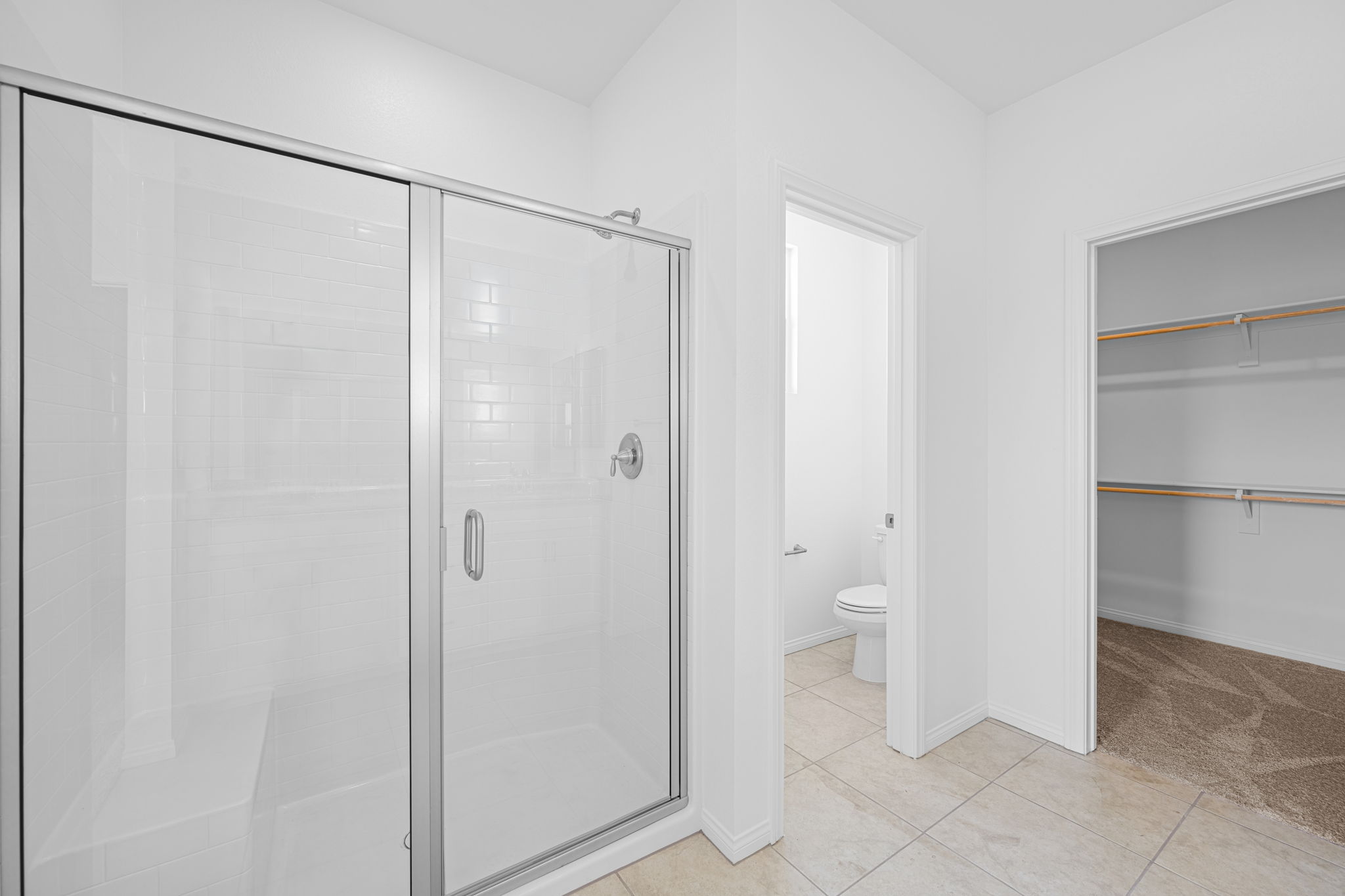 A bathroom with a shower unit and toilet.