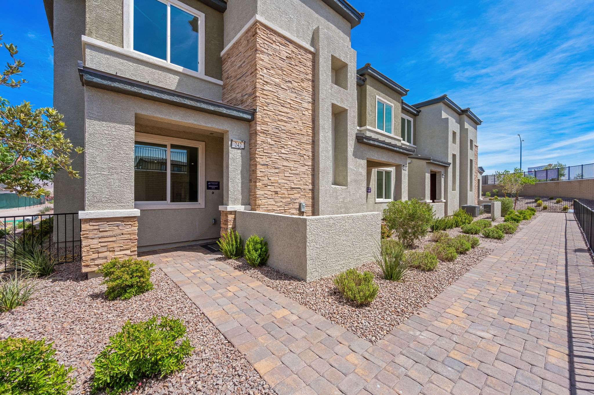 A brick driveway leading to a house.
