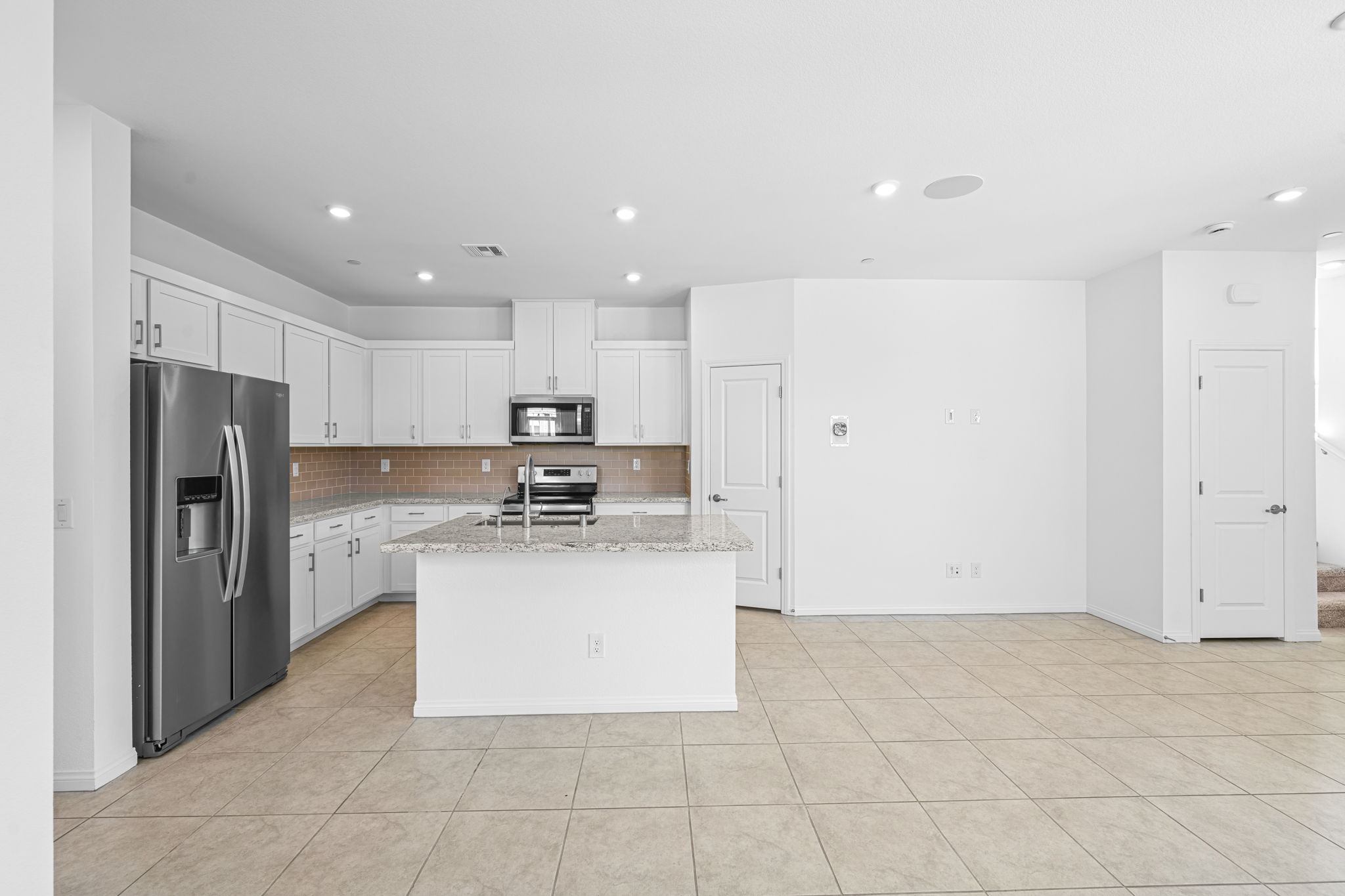 A kitchen with white cabinets.
