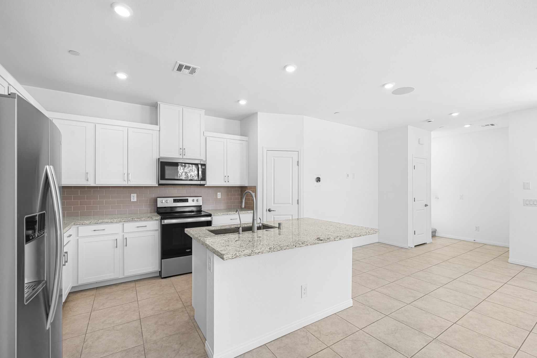 A kitchen with white cabinets.