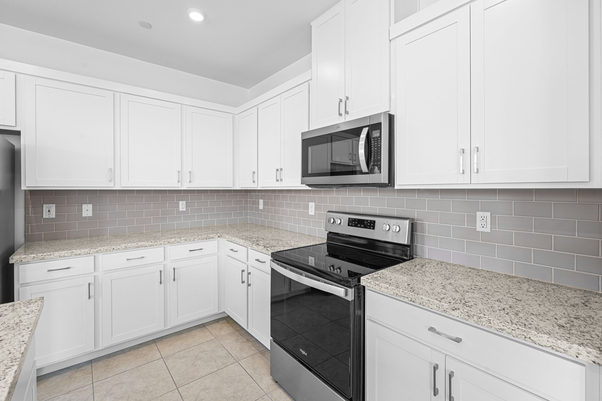 A kitchen with white cabinets.