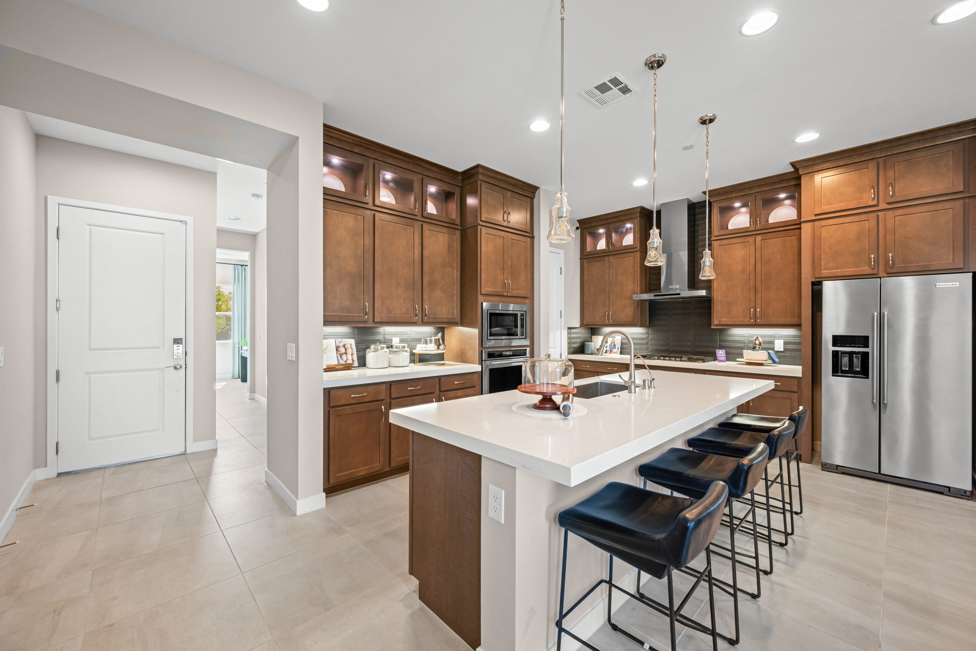 A kitchen with a bar and chairs.