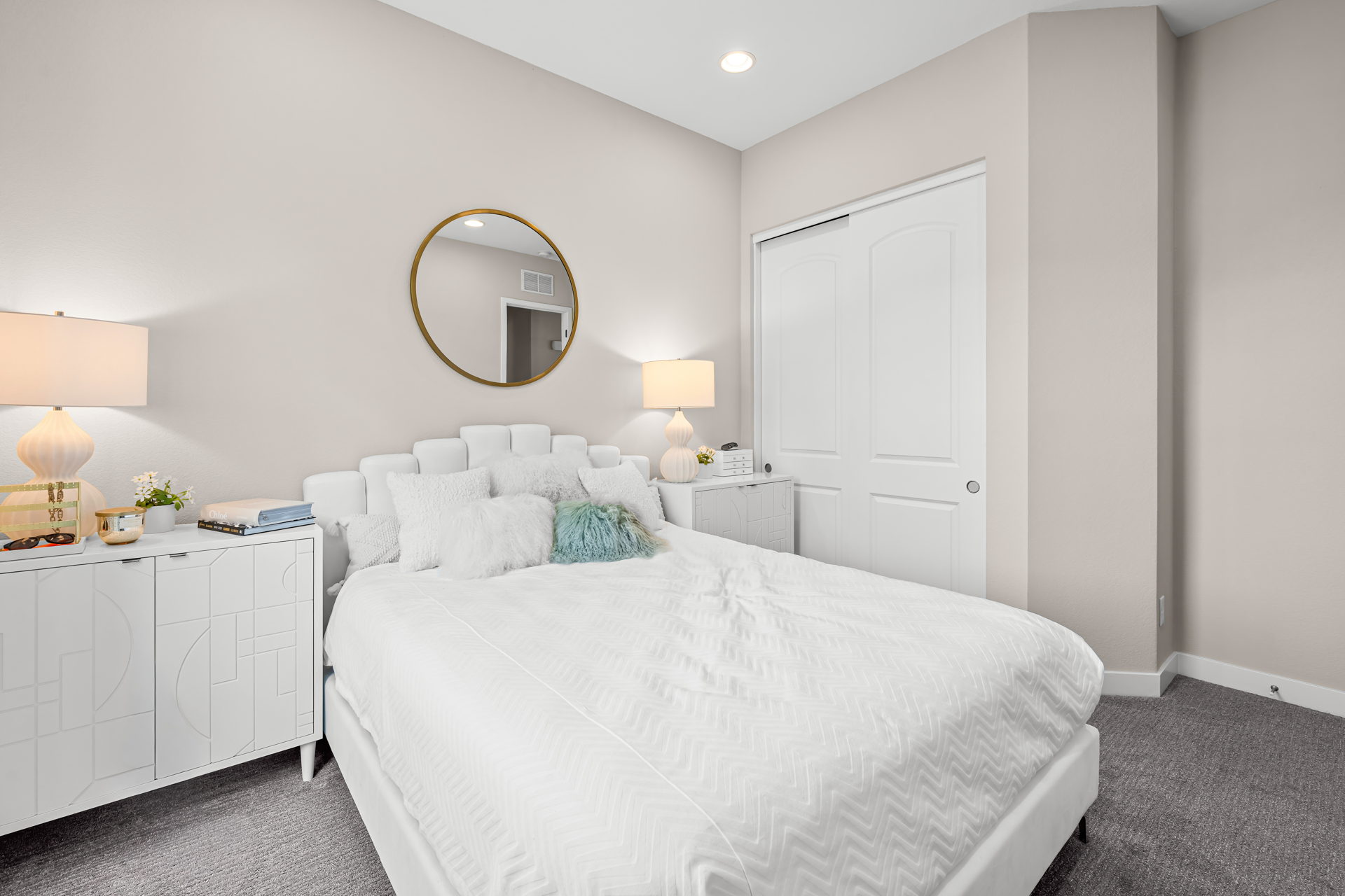A bedroom with a bed and lamps.