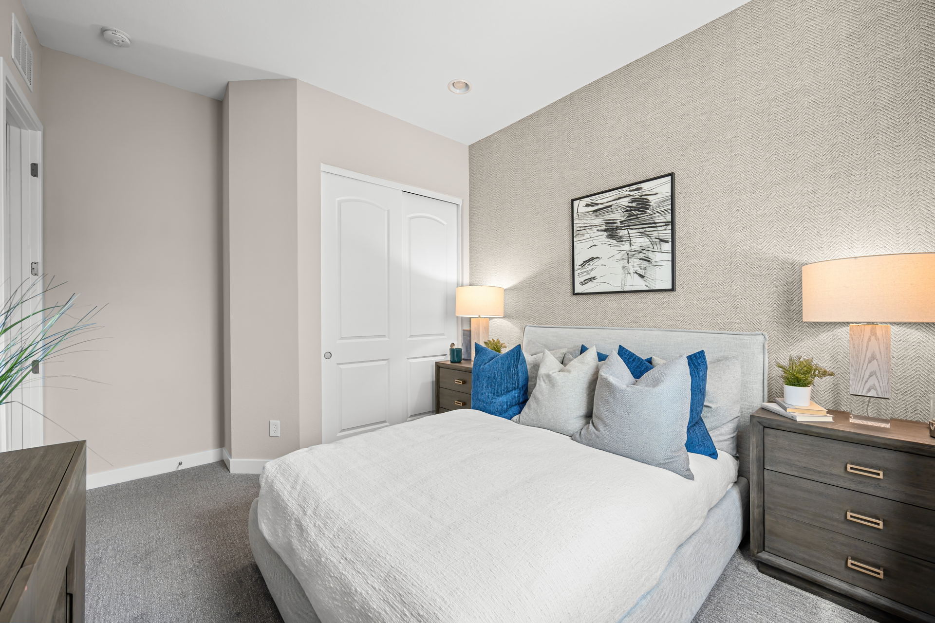 A bedroom with a bed and lamps.