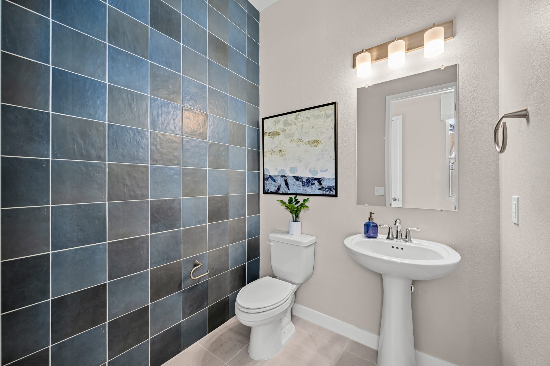 A bathroom with a toilet sink and a mirror.