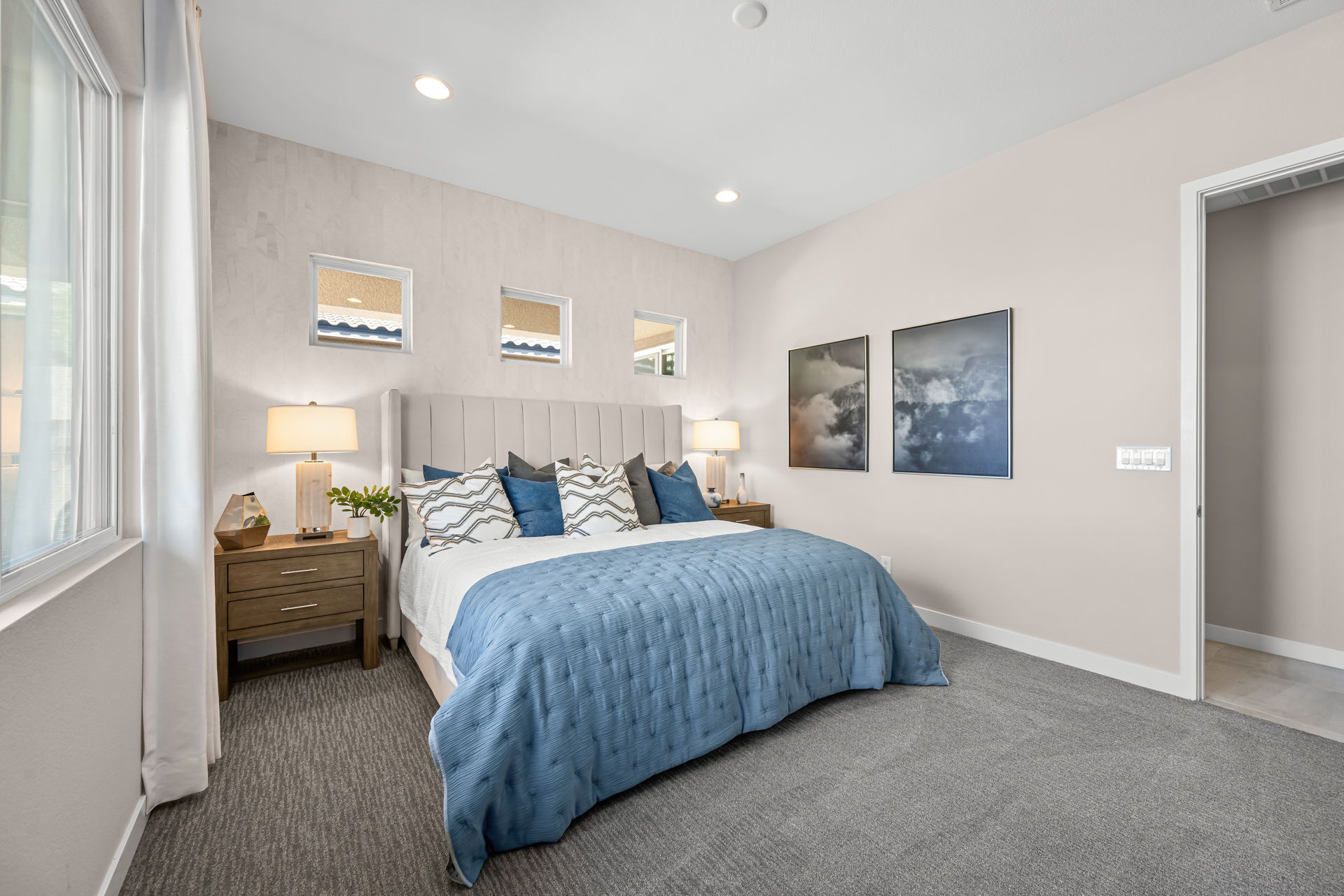 A bedroom with a bed and lamps.