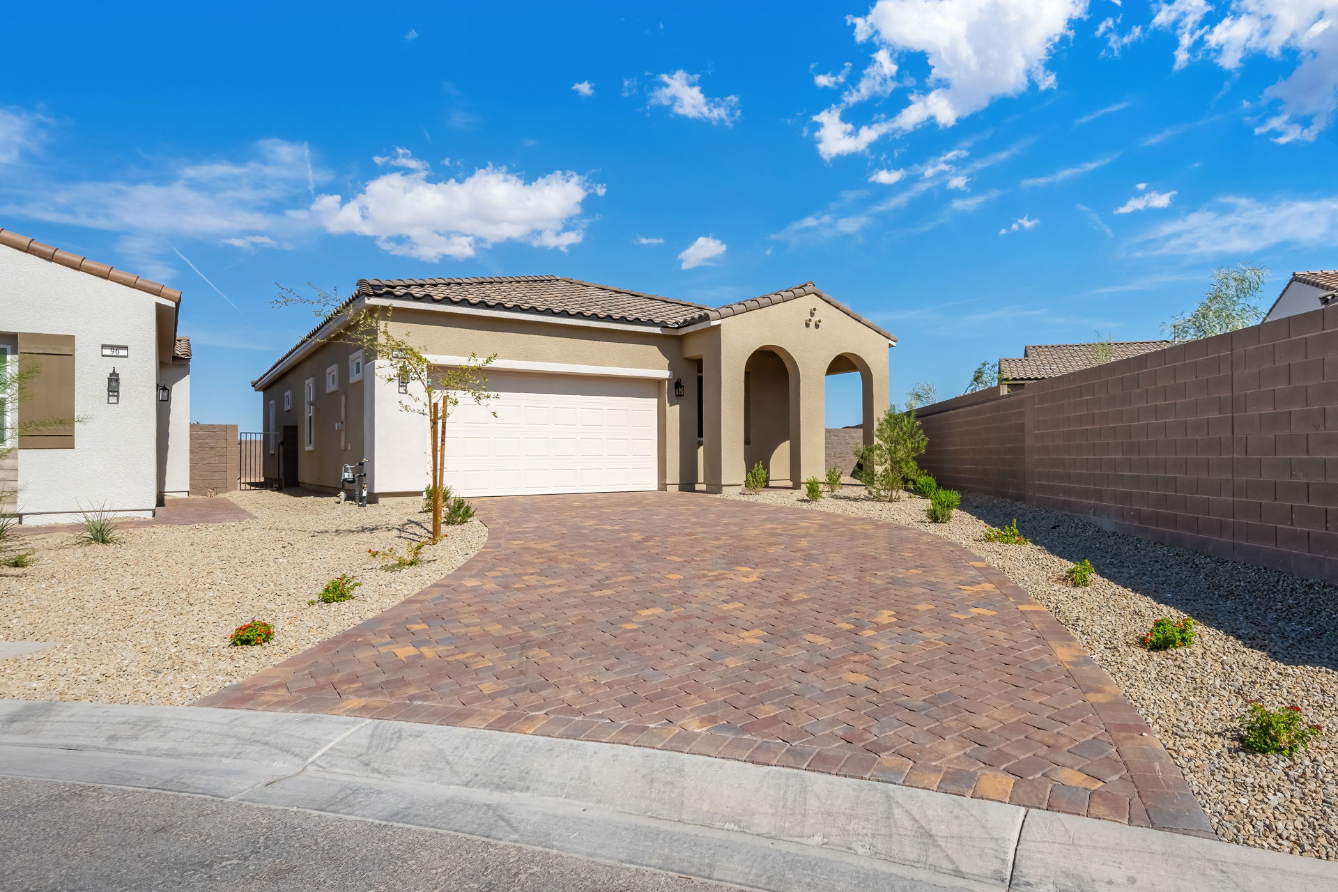 A brick driveway leading to a house.