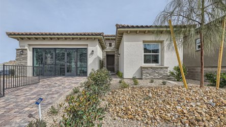 A house with a fence and a gravel driveway.