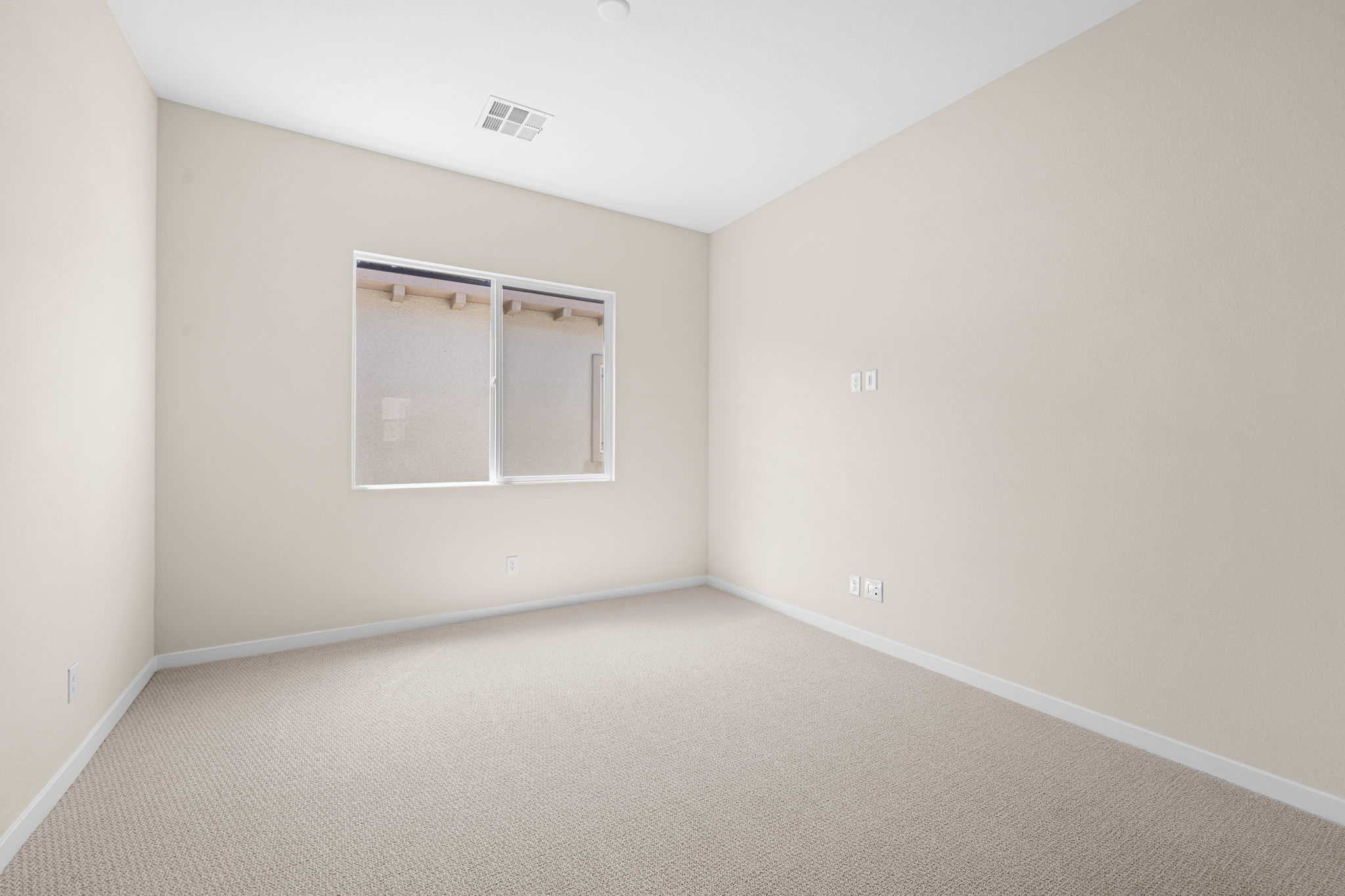 A room with a window and carpet.