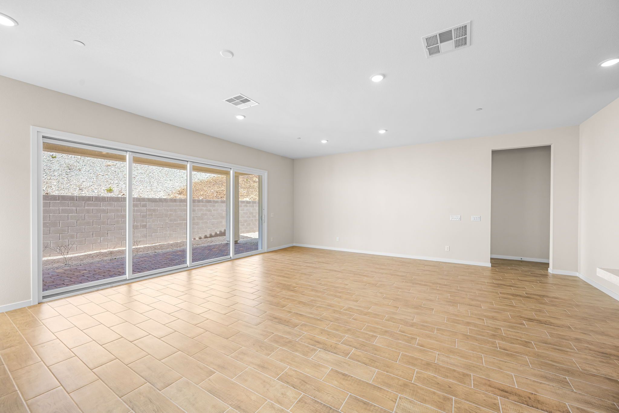 A room with a wood floor and a large window.