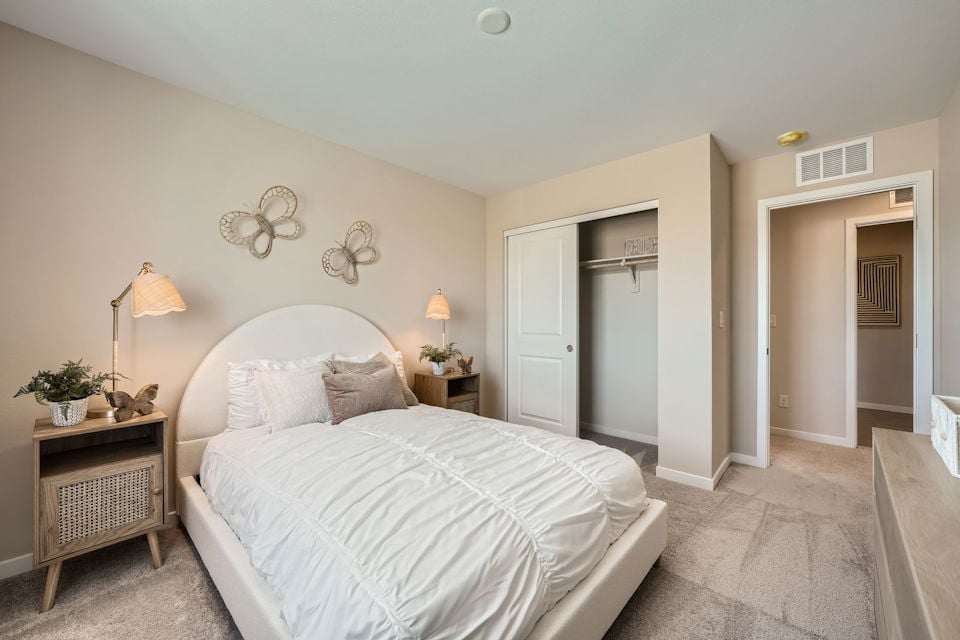 A bedroom with a bed and lamps.